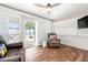 Cozy sunroom featuring wood floors, ceiling fan, and sliding glass door to the outdoor patio space at 8801 Gulf Blvd, St Petersburg, FL 33706