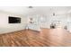 Spacious living room with wood-look floors, white brick wall, and open access to the kitchen and back patio at 8801 Gulf Blvd, St Petersburg, FL 33706