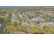 Wide aerial view shows the property and neighborhood with water views from several angles at 965 Westwinds Blvd, Tarpon Springs, FL 34689