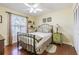 Comfortable bedroom with stylish décor, including an iron bedframe, accent furniture, and natural light at 965 Westwinds Blvd, Tarpon Springs, FL 34689