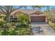 Charming single-Gathering home featuring a lush landscaped front yard and a two-car garage at 965 Westwinds Blvd, Tarpon Springs, FL 34689