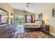 Comfortable main bedroom with hardwood floors and slider to the screened lanai at 965 Westwinds Blvd, Tarpon Springs, FL 34689