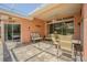 Relaxing outdoor patio featuring stylish seating, ceiling fan, and views of the manicured yard at 965 Westwinds Blvd, Tarpon Springs, FL 34689
