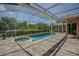 Inviting screened-in pool and spa area perfect for outdoor relaxation and entertaining with a brick paver deck at 965 Westwinds Blvd, Tarpon Springs, FL 34689