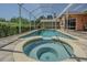Screened pool with attached spa and brick surround offers relaxation and enjoyment at 965 Westwinds Blvd, Tarpon Springs, FL 34689