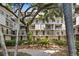 Apartment building exterior featuring balconies, mature trees and manicured landscaping at 105 4Th Ne Ave # 219, St Petersburg, FL 33701