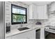 Modern kitchen features white cabinets, stainless steel appliances, and a window with natural light at 105 4Th Ne Ave # 219, St Petersburg, FL 33701