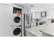 Modern kitchen featuring stainless steel appliances and white cabinetry, with a washer and dryer included at 105 4Th Ne Ave # 219, St Petersburg, FL 33701