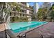 Community swimming pool surrounded by lounge chairs and tropical landscaping at 105 4Th Ne Ave # 219, St Petersburg, FL 33701