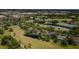 An aerial view showcases this home on a lush golf course with multiple ponds and mature trees at 10600 Indian Hills Ct, Seminole, FL 33777
