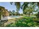 Relaxing backyard with a small pool, manicured lawn, and views of the adjacent lake at 10600 Indian Hills Ct, Seminole, FL 33777