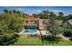 Backyard featuring in-ground pool, hot tub, fire pit, and lush green lawn at 10600 Indian Hills Ct, Seminole, FL 33777