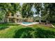 Spacious backyard features a sparkling pool, manicured lawn, and outdoor seating area, ideal for entertaining at 10600 Indian Hills Ct, Seminole, FL 33777
