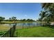 Large backyard overlooking a pond with views of the golf course and mature trees at 10600 Indian Hills Ct, Seminole, FL 33777