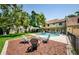 Spacious backyard featuring a fire pit, pool, lush landscaping, and outdoor living space at 10600 Indian Hills Ct, Seminole, FL 33777