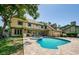 Expansive backyard featuring a sparkling pool, spa, lush landscaping, and a charming home exterior at 10600 Indian Hills Ct, Seminole, FL 33777