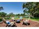 Scenic backyard featuring outdoor seating around a fire pit and a tranquil water view at 10600 Indian Hills Ct, Seminole, FL 33777
