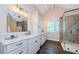 Bright bathroom features granite counters, spacious vanity, and a walk-in shower with decorative tile surround at 10600 Indian Hills Ct, Seminole, FL 33777