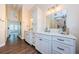 Bright bathroom featuring double vanities with white marble countertops and a glass-enclosed shower at 10600 Indian Hills Ct, Seminole, FL 33777