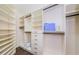 Walk-in closet featuring custom shelving, drawers, and hanging rods for ample storage and organization at 10600 Indian Hills Ct, Seminole, FL 33777