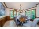 Elegant dining room with wood floors, paneled walls, a decorative chandelier, and large windows providing natural light at 10600 Indian Hills Ct, Seminole, FL 33777