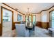 Traditional dining room featuring wood trim, travertine floors, overhead chandelier, and abundant natural light at 10600 Indian Hills Ct, Seminole, FL 33777