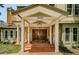 Elegant home entrance featuring a stone facade, brick steps, and a wooden double door with decorative glass panels at 10600 Indian Hills Ct, Seminole, FL 33777