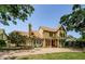 A two-story home with a stone facade entrance, complemented by a spacious front yard and mature trees at 10600 Indian Hills Ct, Seminole, FL 33777
