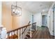 Hallway with wood floors, decorative lighting, and staircase with ornate iron railings at 10600 Indian Hills Ct, Seminole, FL 33777