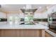 Spacious kitchen featuring a large island with marble countertops and stainless steel appliances at 10600 Indian Hills Ct, Seminole, FL 33777