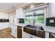 Modern kitchen sink with stainless steel appliances, granite countertops, and view of the pool at 10600 Indian Hills Ct, Seminole, FL 33777