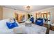 Inviting living room featuring hardwood floors, neutral walls, and blue accent chairs, with a staircase in view at 10600 Indian Hills Ct, Seminole, FL 33777