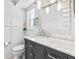 Elegant bathroom featuring a marble countertop, dark vanity, decorative mirror, and modern fixtures at 12536 116Th St, Largo, FL 33778