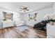 Bright Bedroom with hardwood floors, a ceiling fan, gray curtains, and decorated with a crib and white dresser at 12536 116Th St, Largo, FL 33778