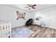 Bright Bedroom with hardwood floors, a ceiling fan, gray curtains, and decorated with a crib and white dresser at 12536 116Th St, Largo, FL 33778