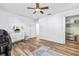 Bright Bedroom with hardwood floors, a ceiling fan, gray curtains, and decorated with a crib and white dresser at 12536 116Th St, Largo, FL 33778