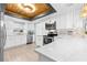 Modern white kitchen features stainless steel appliances, white marble countertops, and wood ceiling at 12536 116Th St, Largo, FL 33778