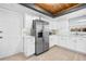 White kitchen features stainless appliances, contrasting countertops, and eye-catching wood ceiling at 12536 116Th St, Largo, FL 33778