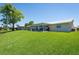 Rear exterior showcasing a well-maintained yard and screened-in porch at 13797 Pinecrest Dr, Largo, FL 33774