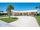 Inviting home showcasing a lush lawn, mature landscaping, and a convenient two-car garage, and circular driveway at 13797 Pinecrest Dr, Largo, FL 33774