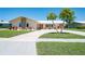 Charming home featuring a well-maintained lawn, decorative plantings, and a spacious driveway for ample parking at 13797 Pinecrest Dr, Largo, FL 33774
