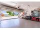 View of the garage with open overhead door, epoxy flooring, and tool storage at 13797 Pinecrest Dr, Largo, FL 33774