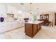 Modern kitchen features white cabinetry, quartz countertops, stainless steel appliances, and a large island at 13797 Pinecrest Dr, Largo, FL 33774