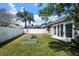 Lush backyard with verdant grass, raised garden planters, and a white fence, offering a serene outdoor living space at 1418 Hurley Pond Ln, Valrico, FL 33596