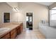 Bathroom with large vanity area, soaking tub, step-in shower, and stylish tile flooring and an ensuite bathroom at 1418 Hurley Pond Ln, Valrico, FL 33596