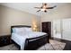 Bedroom with dark wood furnishings, plush rug, ensuite bath, and a ceiling fan providing comfort and convenience at 1418 Hurley Pond Ln, Valrico, FL 33596