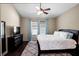 Well-lit bedroom with hardwood floors, white bedding, dark dresser, and a ceiling fan providing comfort and style at 1418 Hurley Pond Ln, Valrico, FL 33596