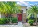 Inviting front entrance with a red door framed by stone accents and lush greenery at 1418 Hurley Pond Ln, Valrico, FL 33596
