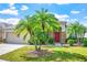 Charming home exterior with lush landscaping, a vibrant red front door, and a well-manicured lawn at 1418 Hurley Pond Ln, Valrico, FL 33596
