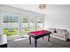 Bright game room boasts a billiard table, comfortable seating, and sliding doors to the outdoors at 1418 Hurley Pond Ln, Valrico, FL 33596